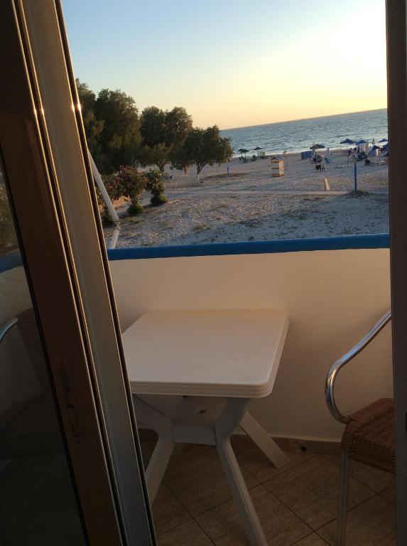 a view of the beach from a window with a bench at Katerina & Efi Apartments in Mastichari