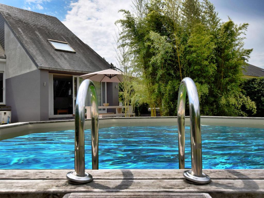 ヴィルトンにあるHoliday Home in Virton with swimming poolの家の隣に2本の金属製のレールがあるスイミングプール