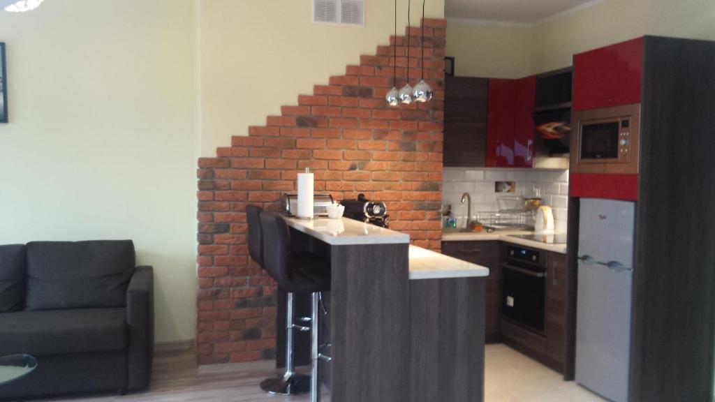 - une cuisine avec un mur en briques et un comptoir dans l'établissement Apartament Relax, à Giżycko