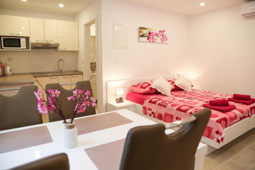 a bedroom with a bed and a table and a kitchen at Apartments Lea in Hvar