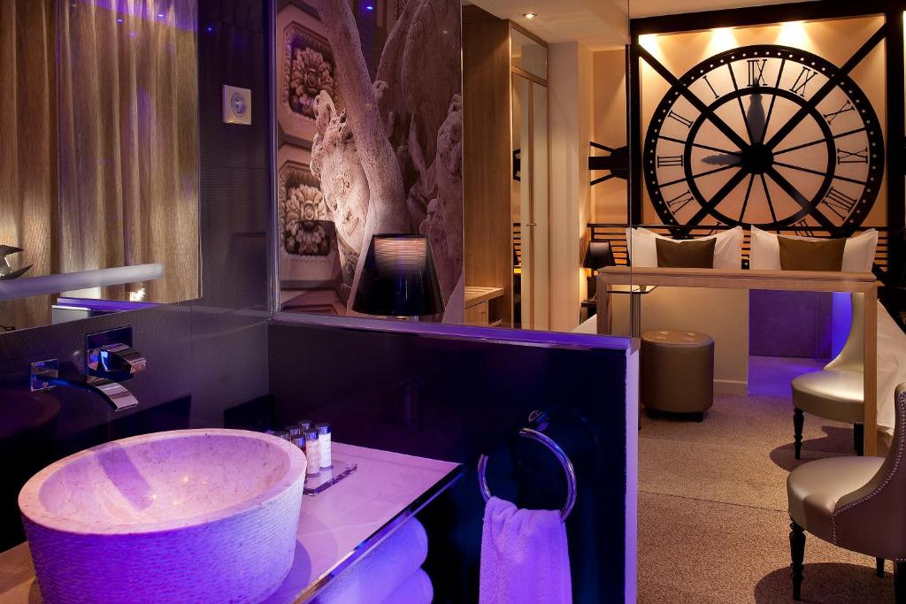 a bathroom with a sink and a large wheel on the wall at Secret de Paris - Hotel & Spa in Paris