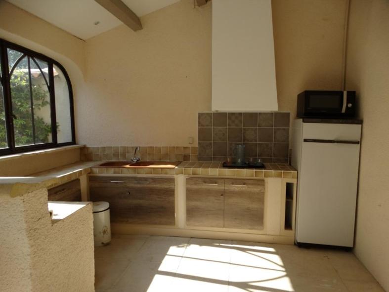 a kitchen with a sink and a refrigerator at L&#39;Oustau de Bigatié in Lambesc