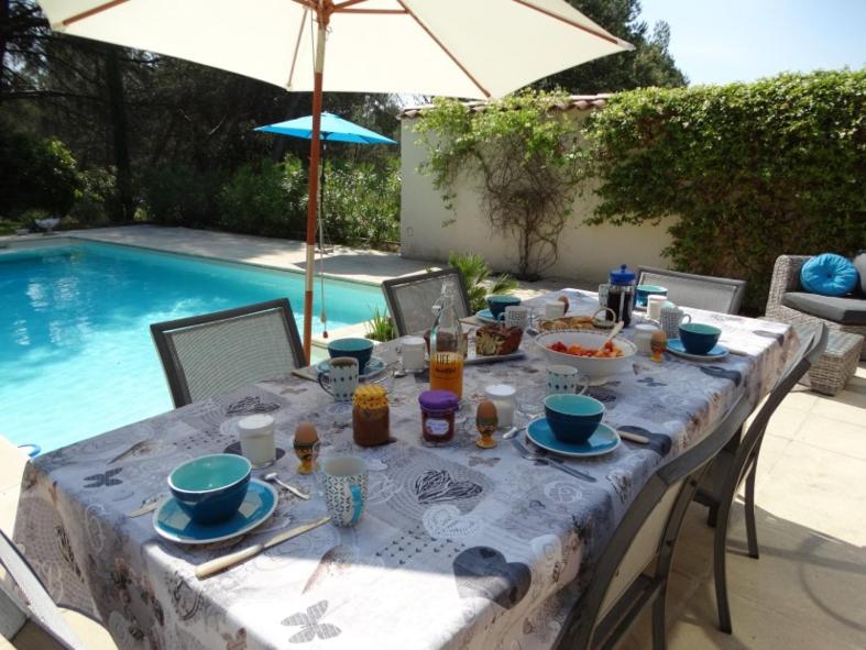 a table with food on it next to a swimming pool at L&#39;Oustau de Bigatié in Lambesc