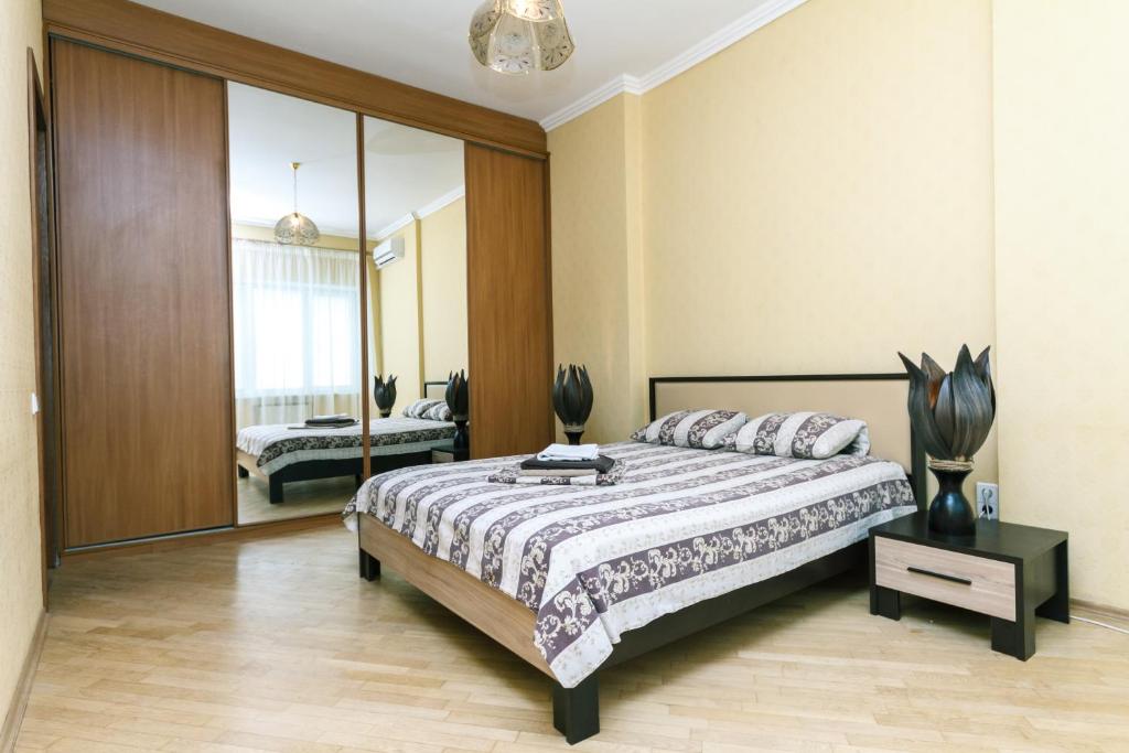 キーウにあるApartment on Khreshchatykのベッドルーム(大型ベッド1台、鏡付)