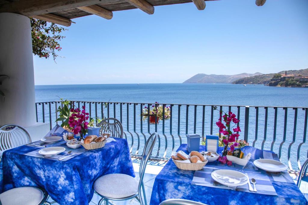 una mesa con sillas y vistas al océano en B&B Alta Marea Lipari, en Lipari