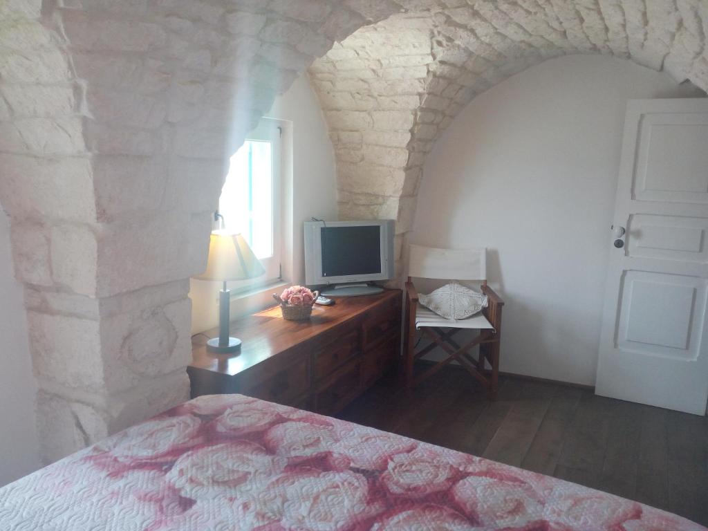 Dormitorio con cama y tocador con TV en Casa Indipendente Settecentesca AIRCON Wifi Vista Mare, en Ostuni