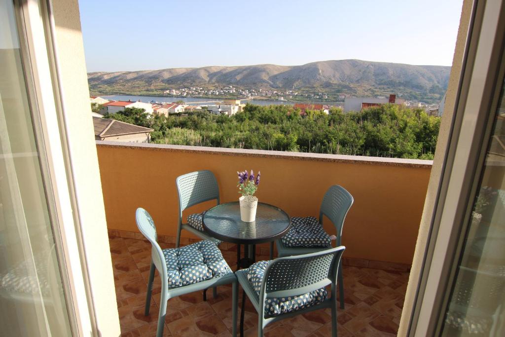 einen Tisch und Stühle auf einem Balkon mit Aussicht in der Unterkunft Family Apartments House Damir in Pag