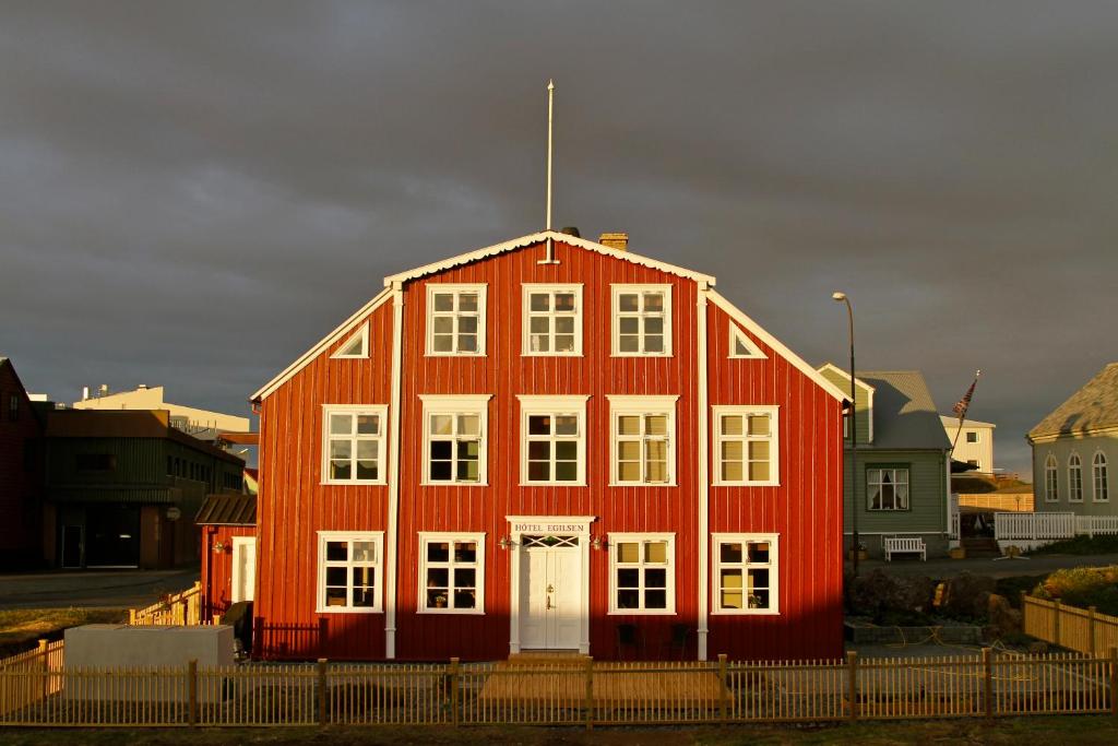 a red house with a white door in front at Hótel Egilsen in Stykkishólmur