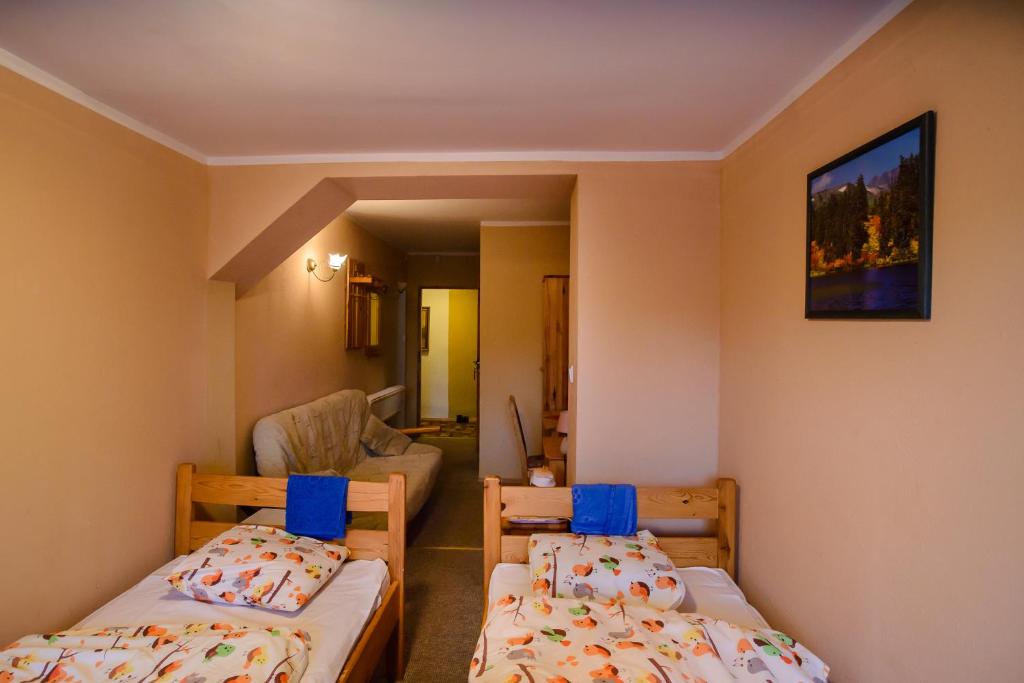 a small room with two beds and a couch at Chata Baryła in Sulęczyno