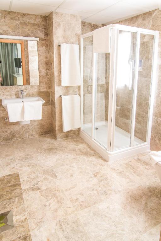 a bathroom with a shower and a sink at Hotel Senderos in Agua Amarga