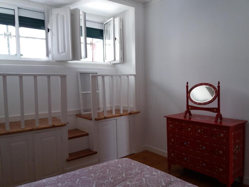een kamer met een spiegel, een dressoir en een raam bij Casa dos Azulejos in Lissabon