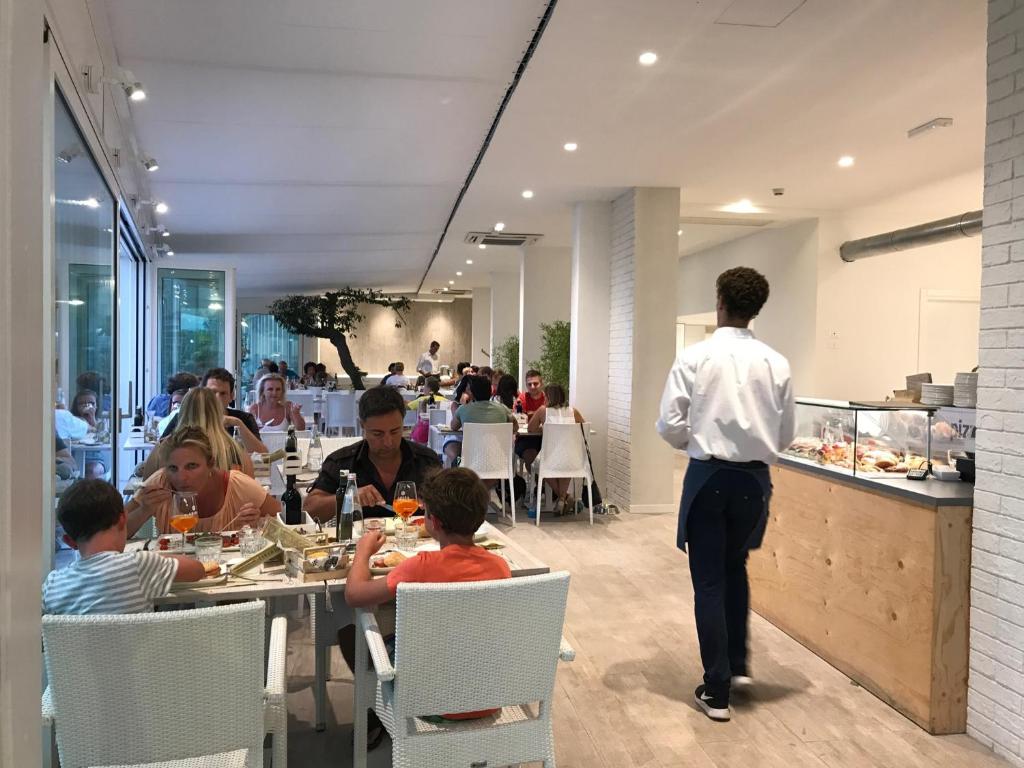 a man standing in a restaurant with people sitting at tables at Stellamare in Caorle