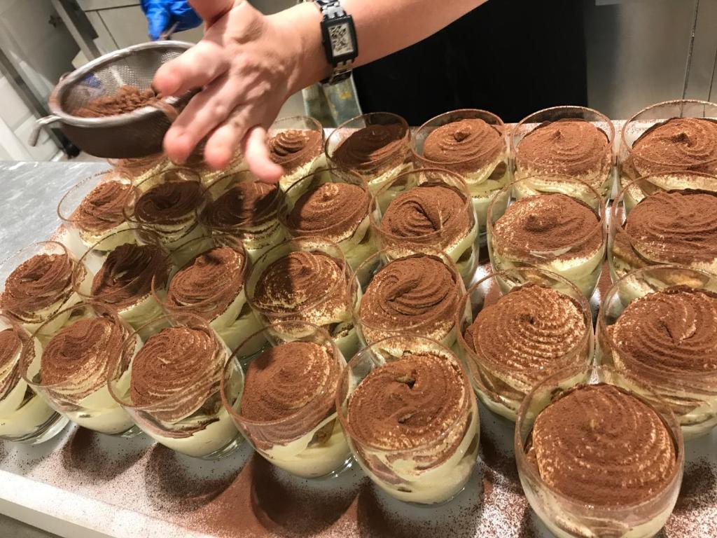a person is reaching for a tray of desserts at Stellamare in Caorle