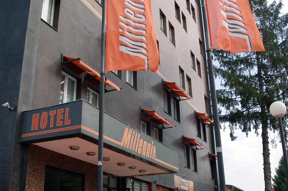 un hotel con banderas de color naranja frente a un edificio en Millennia Rooms Ruse en Ruse