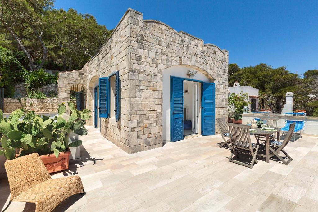 une maison en pierre avec une porte bleue et une terrasse dans l'établissement Terrazza sul mare by BarbarHouse, à Santa Cesarea Terme