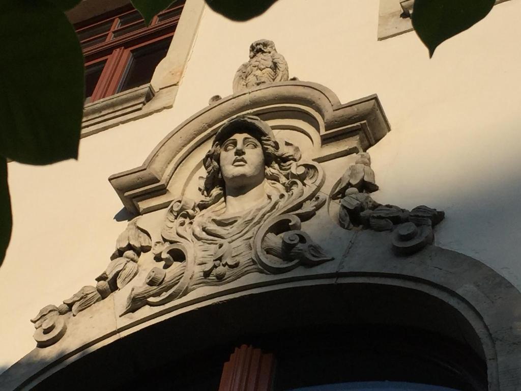 a statue of a man on the side of a building at Villa am Grossen Garten in Dresden