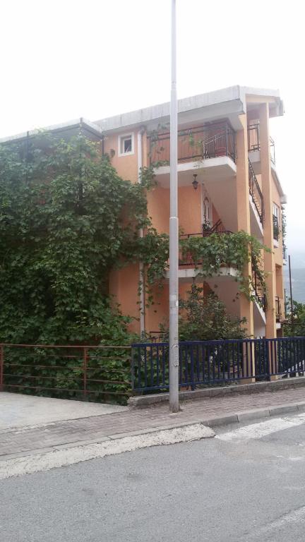 ein Gebäude an der Seite einer Straße mit einem Zaun in der Unterkunft Guesthouse Djacic in Budva