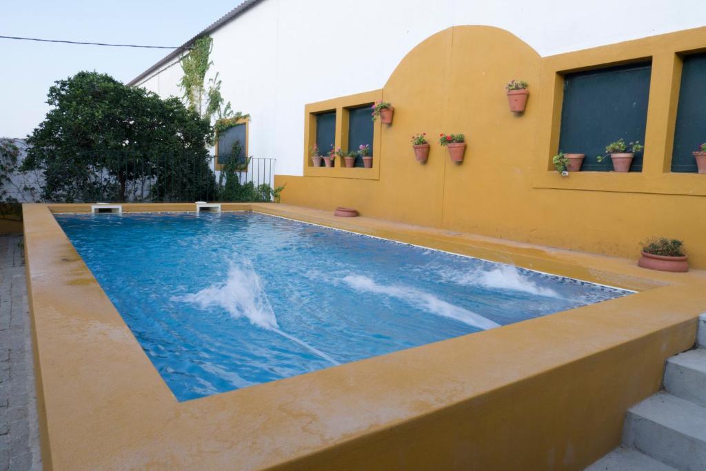 uma piscina ao lado de um edifício em Casa Rural Dehesa de Solana em Herrera de Alcántara