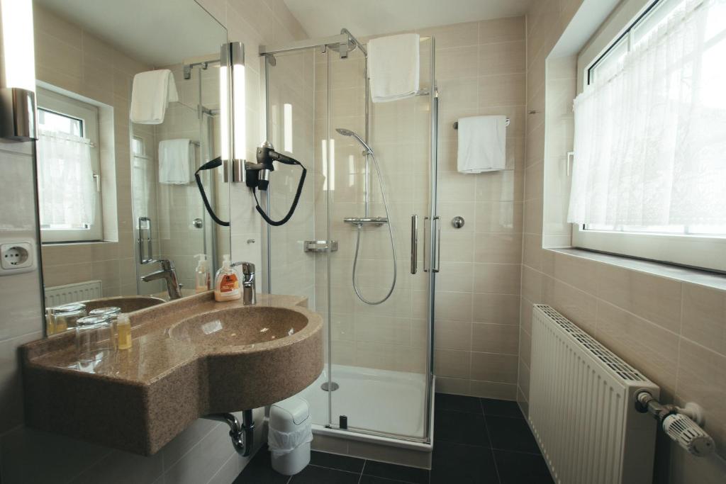 a bathroom with a sink and a shower at Hotel-Restaurant Walkmühle in Usingen