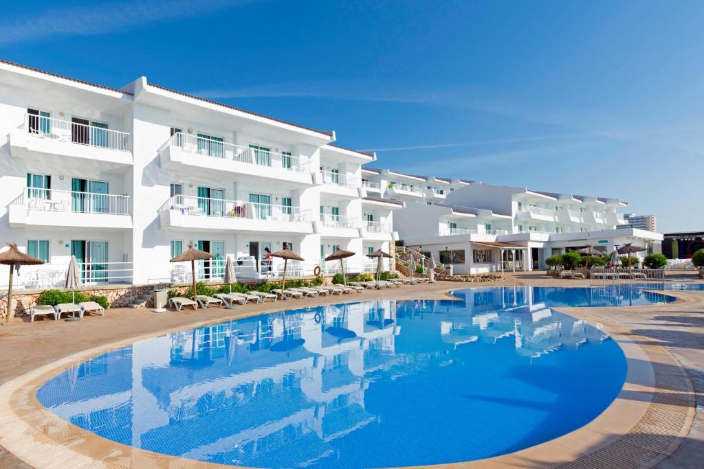 um hotel com piscina em frente a um edifício em HSM Calas Park em Calas de Mallorca