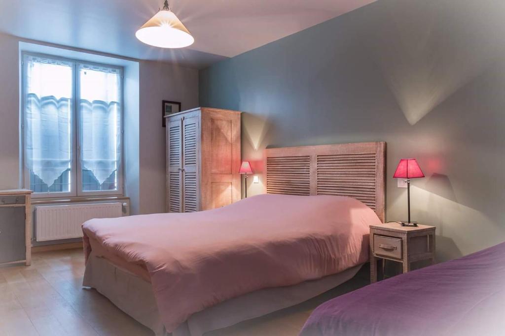 a bedroom with a large bed and a window at L'Auberge de Teissières in Teissières-lès-Bouliès