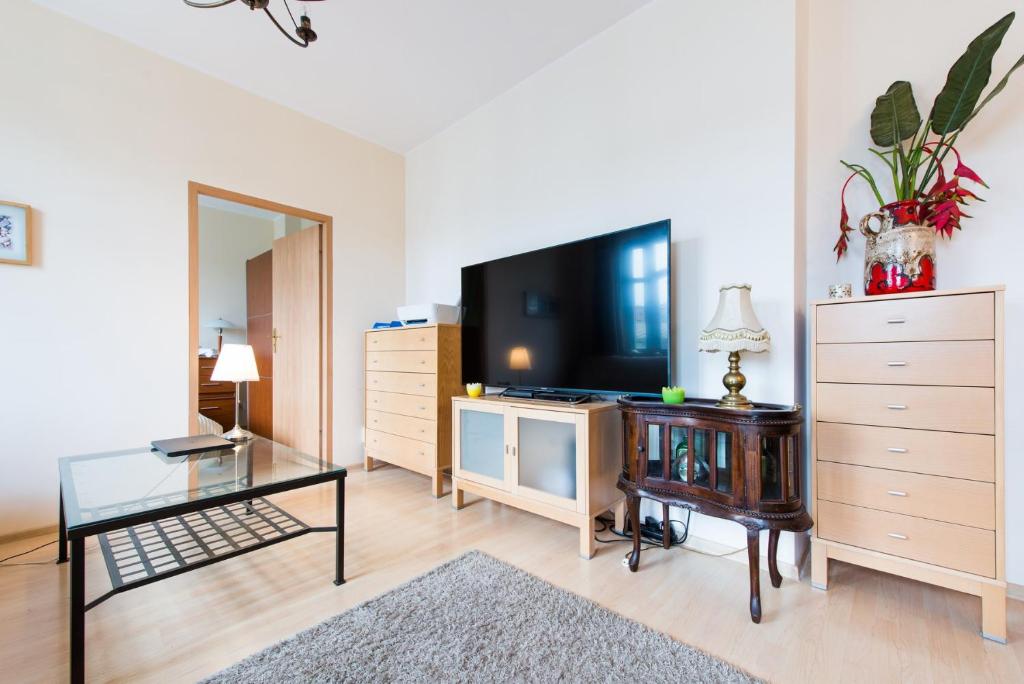 a living room with a tv and a glass table at MW Apartamenty - MONTE CASSINO in Sopot