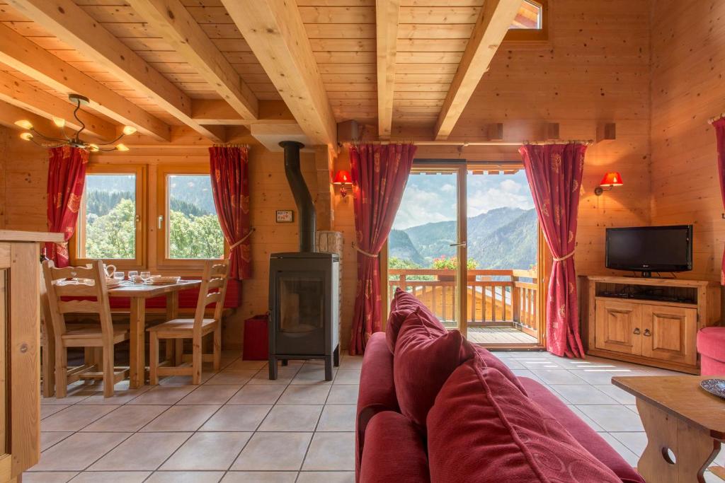 ein Wohnzimmer mit einem Sofa und einem Tisch mit Aussicht in der Unterkunft Les Chalets du Danay in Saint-Jean-de-Sixt