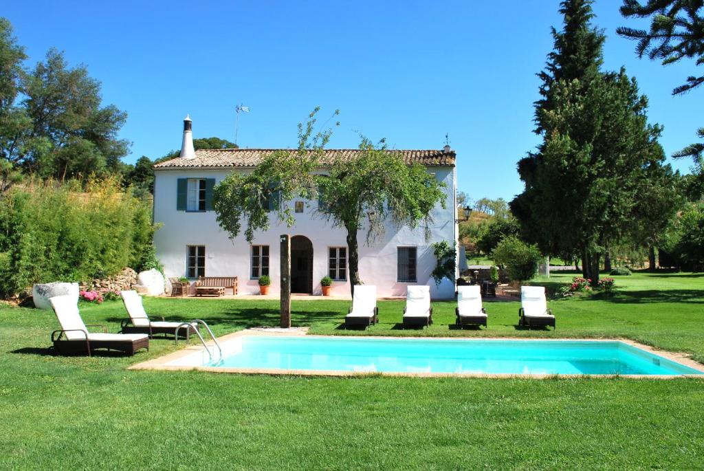 a villa with a swimming pool in front of a house at La Escribana in Constantina