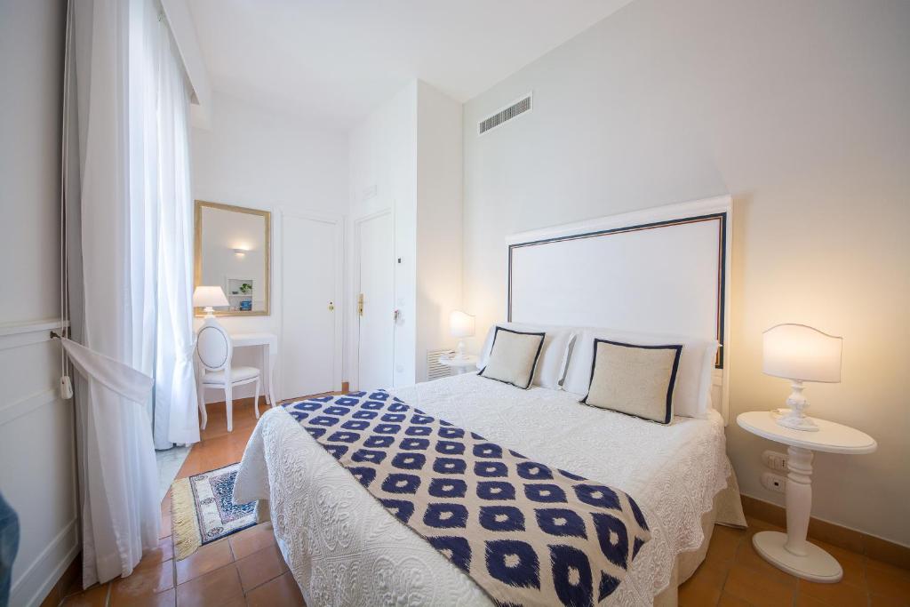 a hotel room with a white bed and white walls at Villa Romana Hotel & Spa in Minori