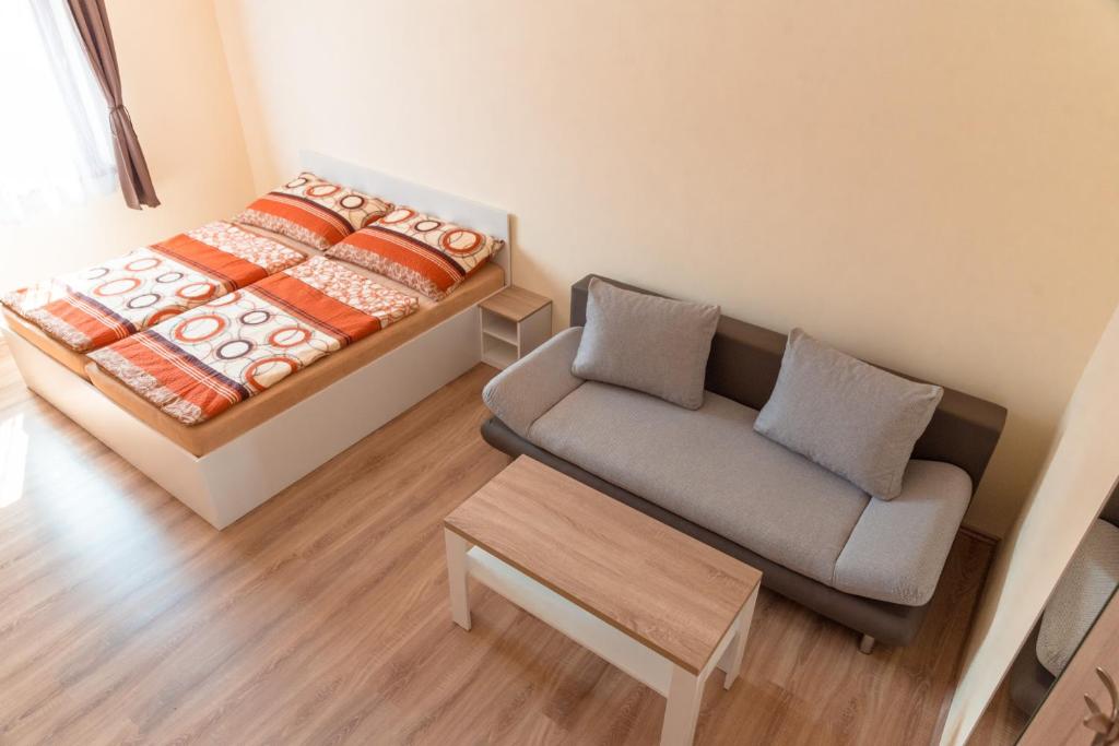 Habitación pequeña con sofá y cama en Nad Šťastným sklepem en Valtice