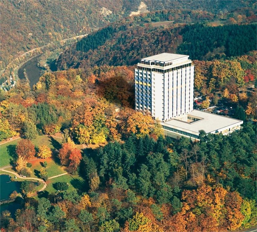 un edificio alto y blanco en medio de un bosque en Wyndham Garden Lahnstein Koblenz en Lahnstein