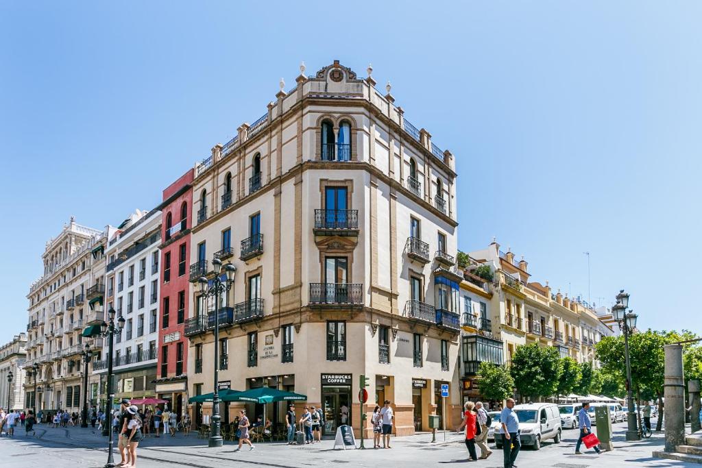 wysoki budynek z ludźmi przed nim. w obiekcie Apartamento Living By Cathedral w Sewilli