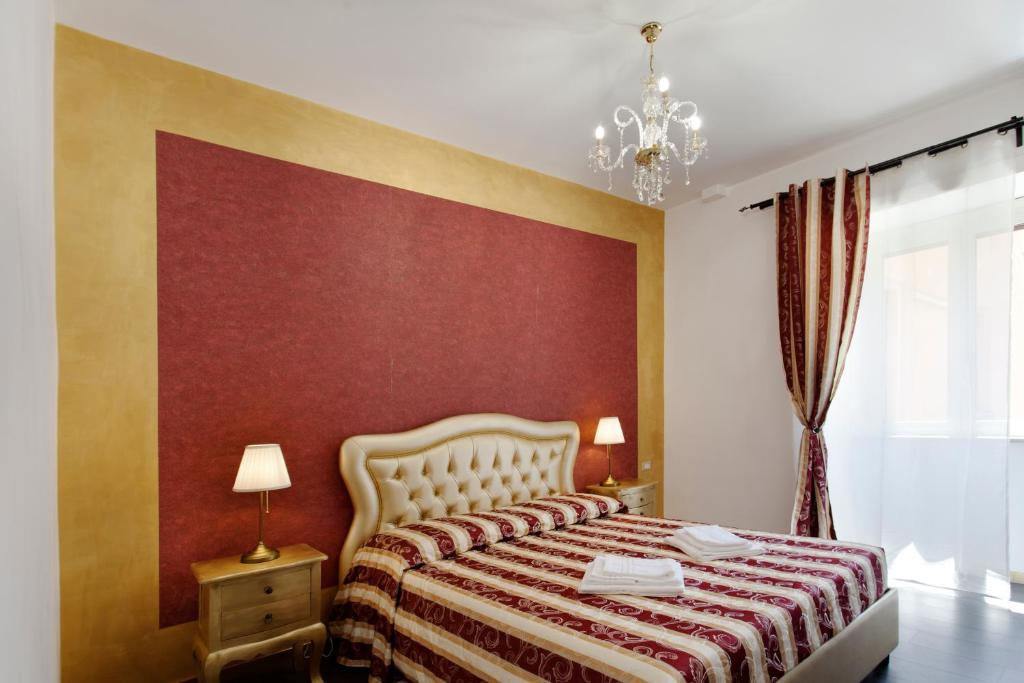 a bedroom with a bed with a red wall at Secret Rhome in Rome