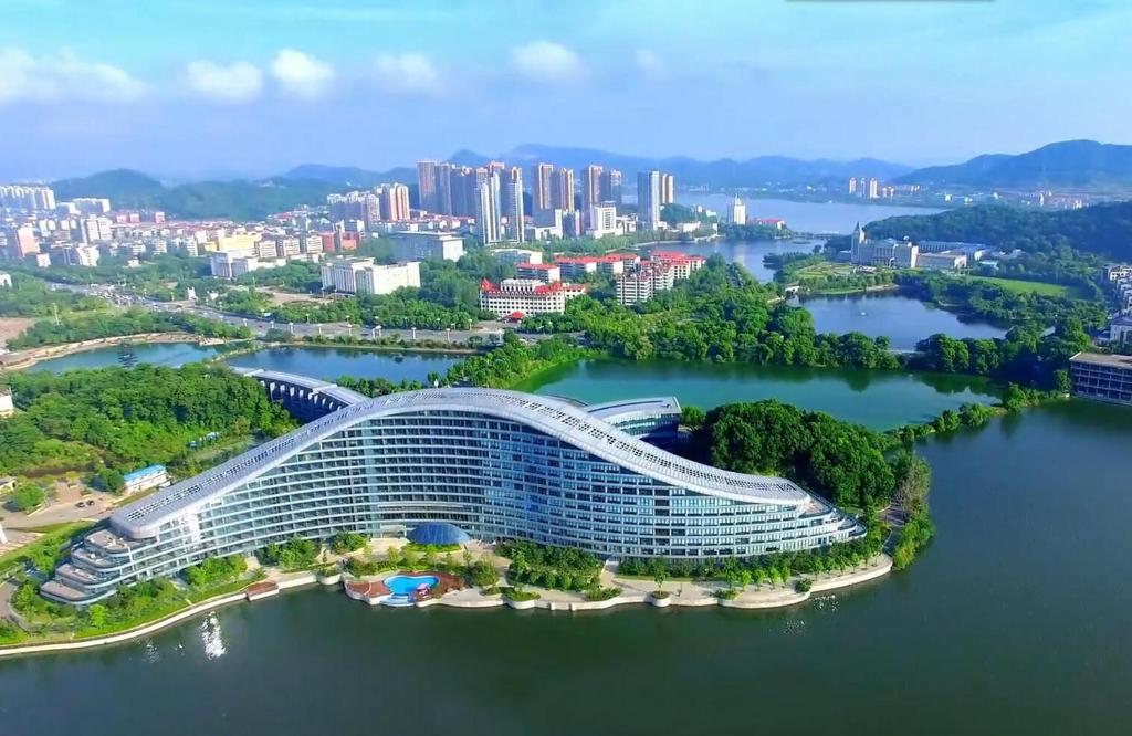 an aerial view of a building on a river with a city at Wingtech Hotel in Huangshi