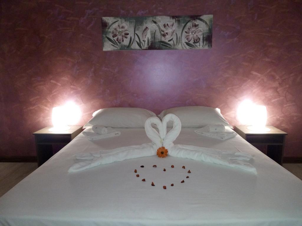 a white bed with a bow on it with two lights at B&B Contesse in Messina