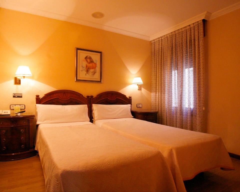 Postel nebo postele na pokoji v ubytování Hostal Victoria III