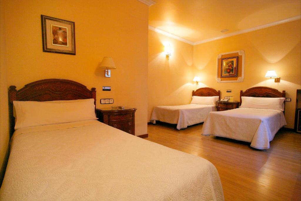 Postel nebo postele na pokoji v ubytování Hostal Victoria III
