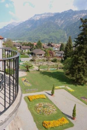 a balcony with a view of a park with mountains at Mattenhof Resort in Interlaken