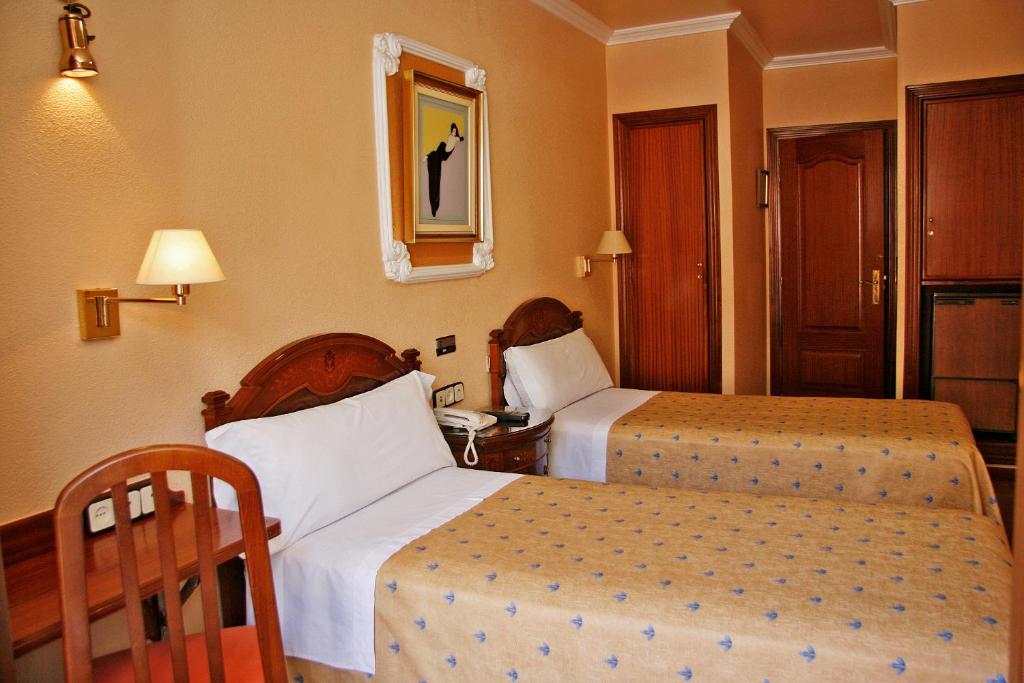 Postel nebo postele na pokoji v ubytování Hostal Victoria III