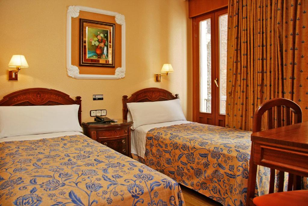 Postel nebo postele na pokoji v ubytování Hostal Victoria III