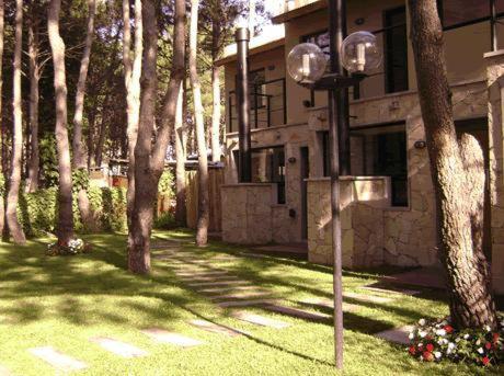 una luz de la calle frente a una casa con árboles en Aylen Departamentos en Pinamar en Pinamar