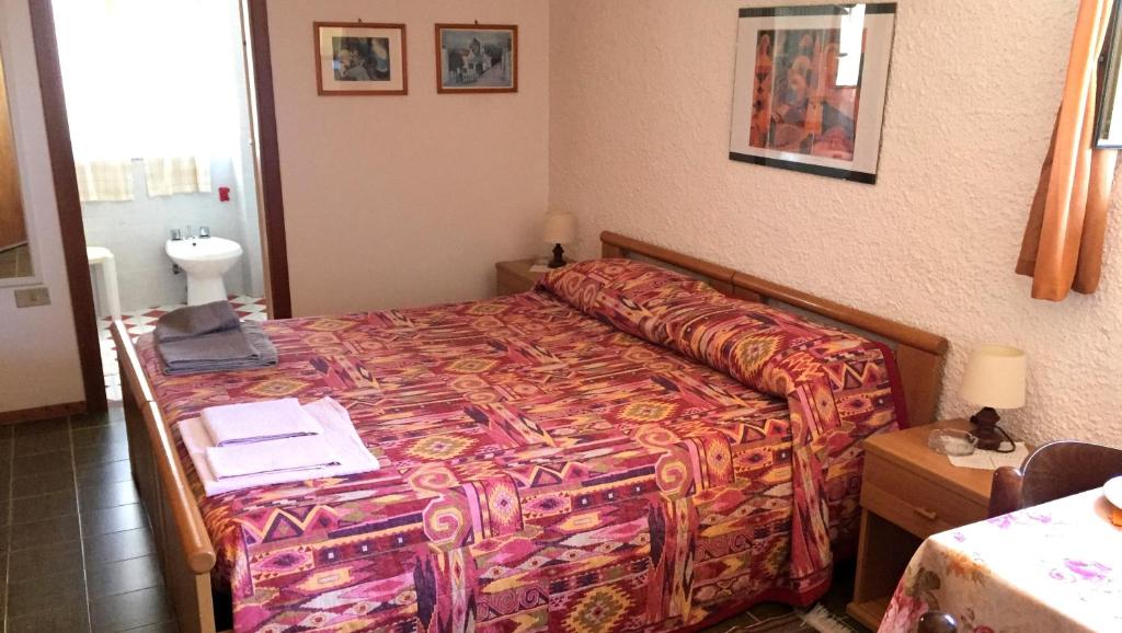 1 dormitorio con 1 cama con ordenador portátil en B&B Pani Silvio, en Perfugas