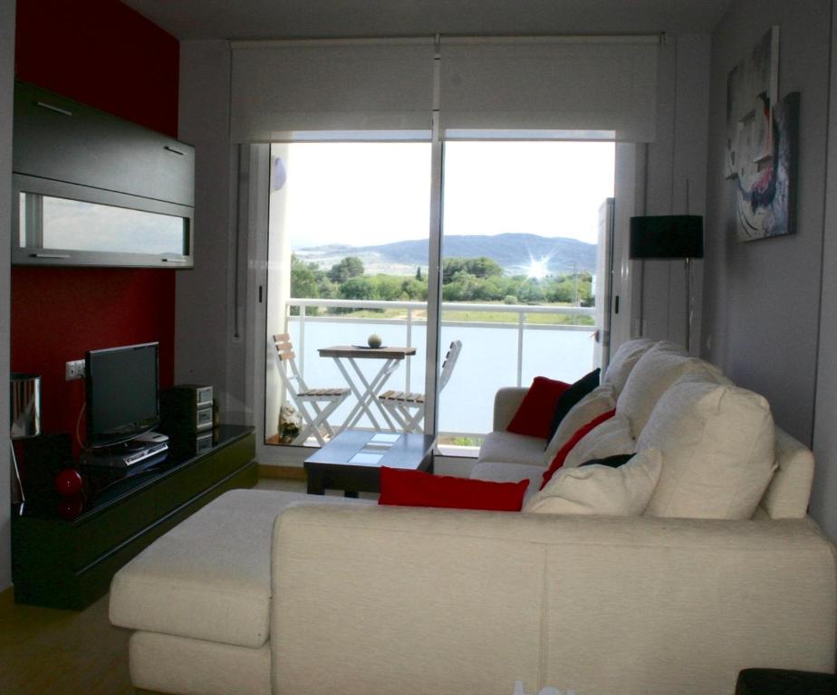 sala de estar con sofá blanco y TV en Apartamento Can Xavi, en Santa Bárbara