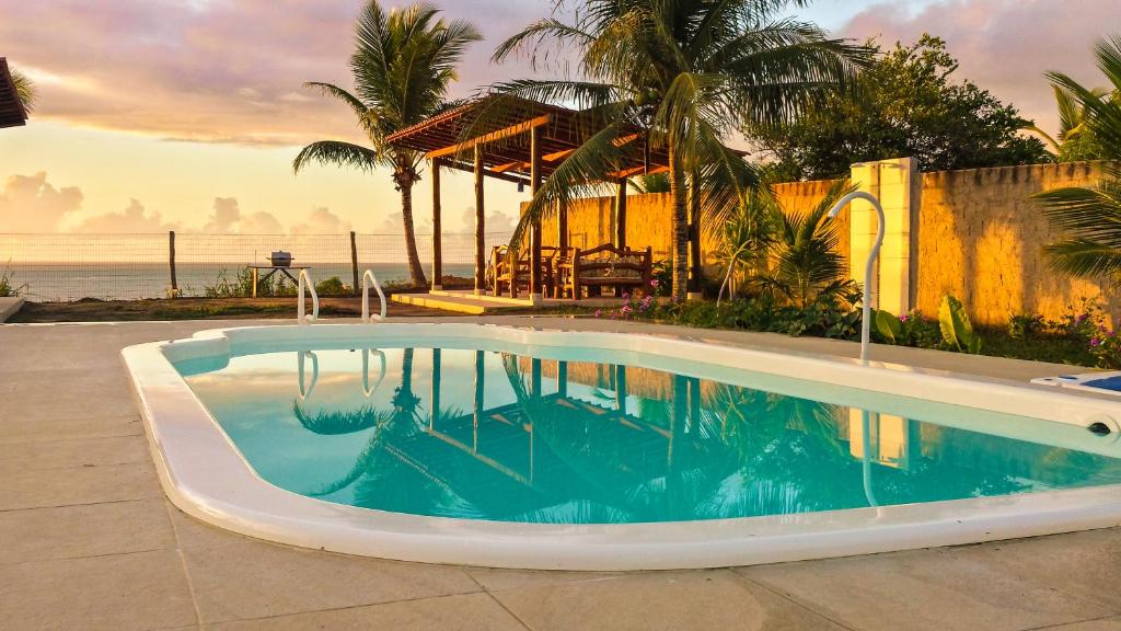 a swimming pool with a view of the ocean at Pousada Azul com vistas maravilhosas in Cumuruxatiba