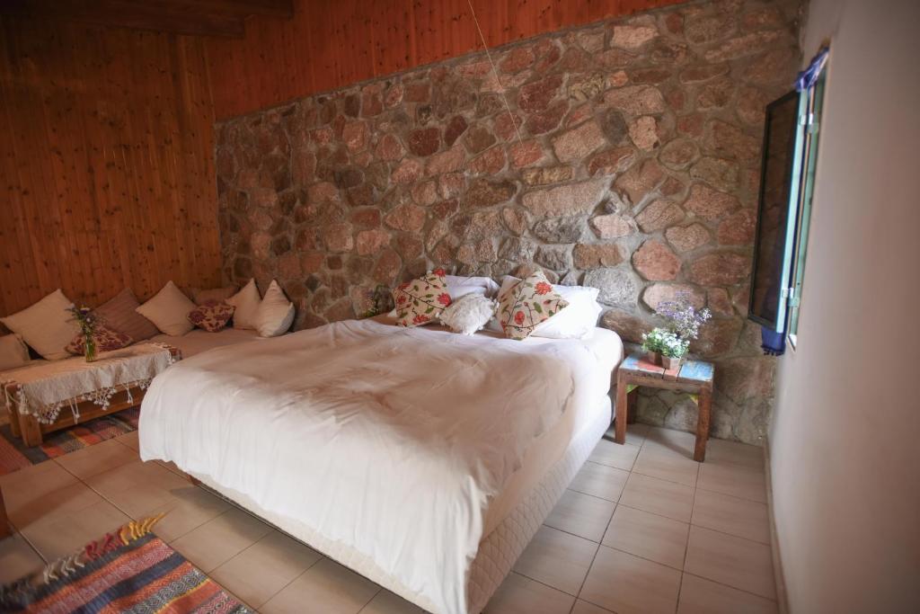 a bedroom with a bed and a stone wall at Williams House in Eilat