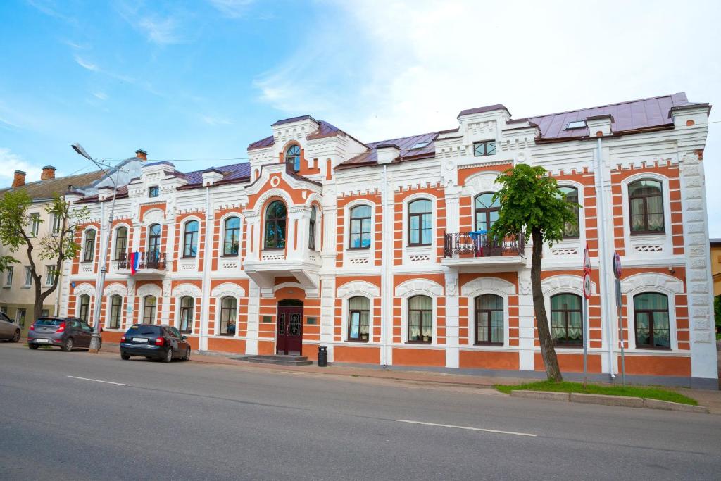 a large orange and white building on the side of a street at Rachmaninoff Hotel in Velikiy Novgorod