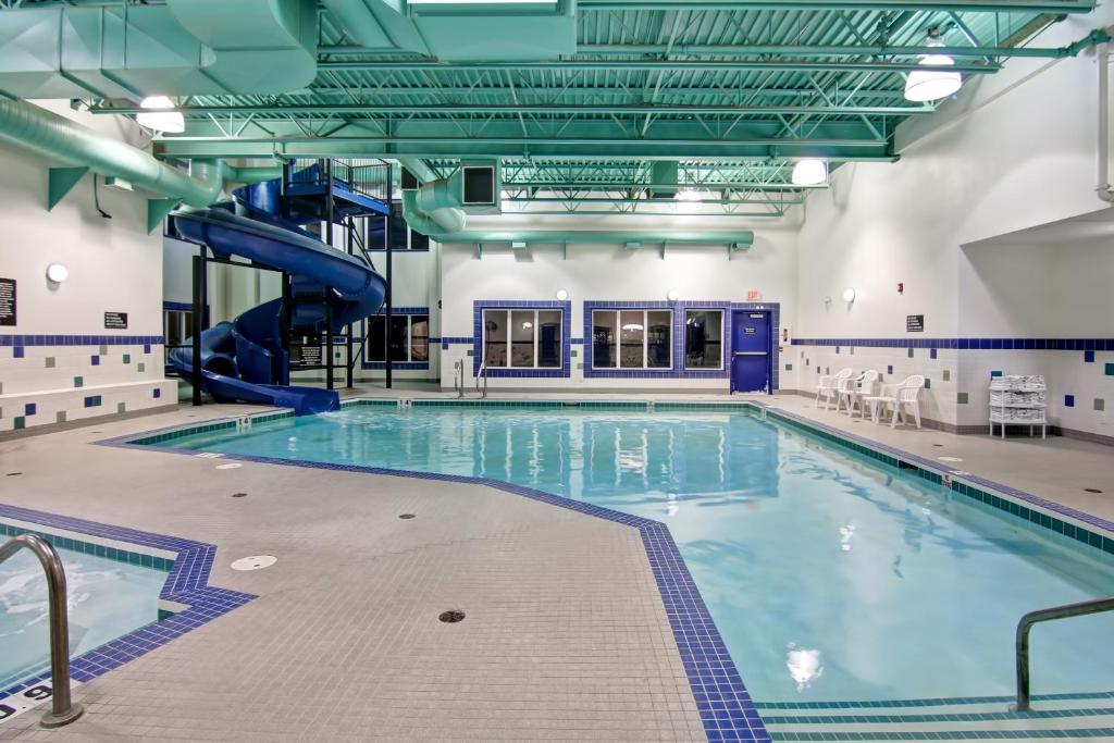 a large indoor swimming pool with a slide at Canalta Stettler in Stettler