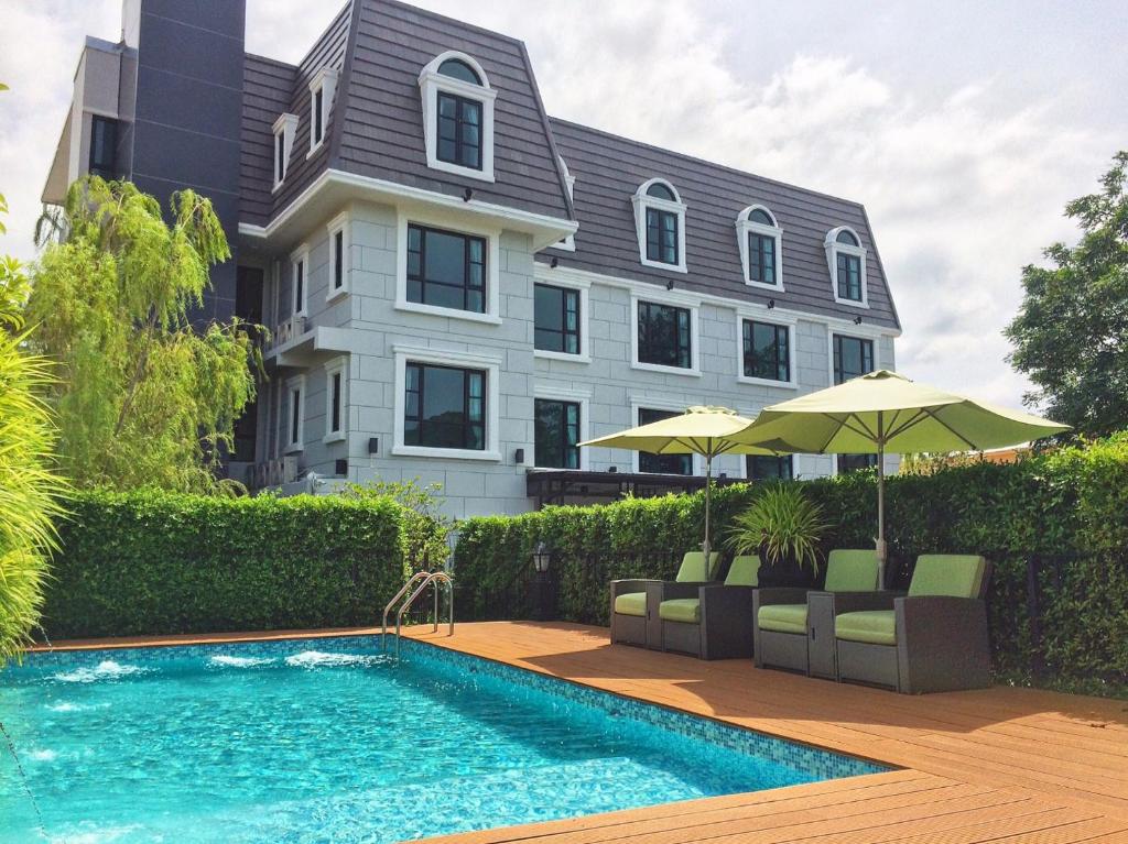 a house with a swimming pool in front of a house at Marquise Boutique Hotel in Rayong