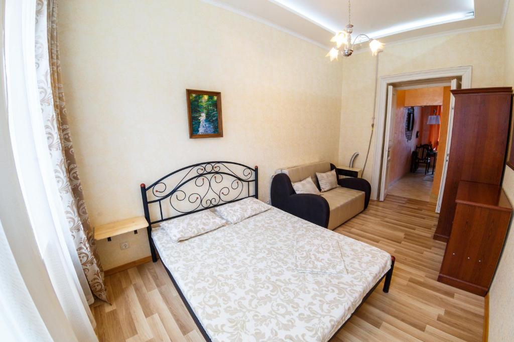 リヴィウにあるZamarstynivska apartmentの小さなベッドルーム(ベッド1台、ソファ付)