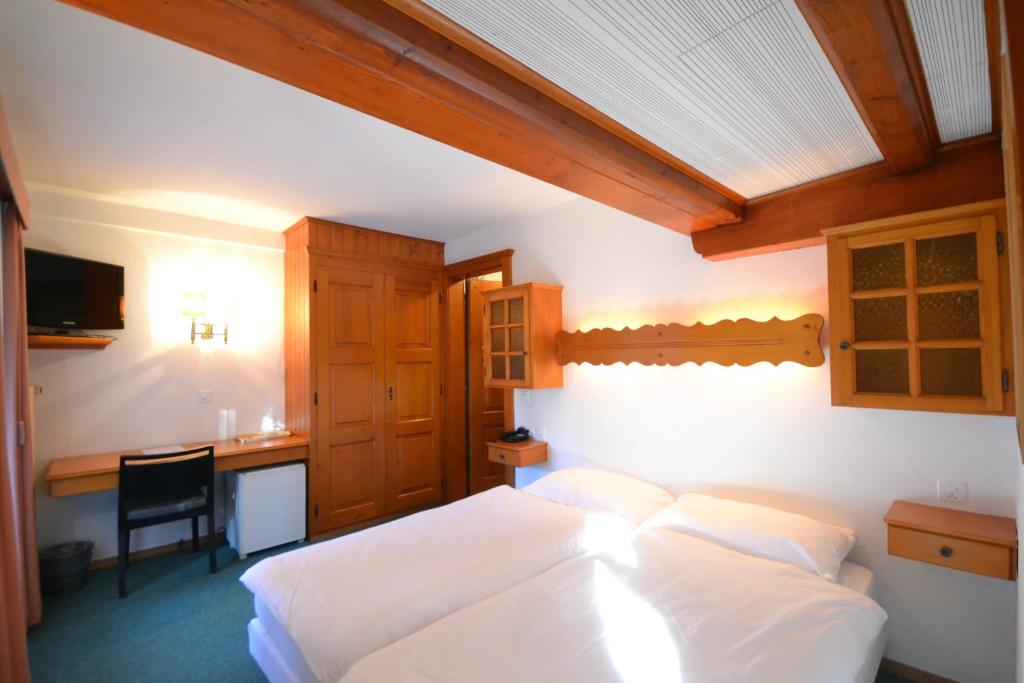Postel nebo postele na pokoji v ubytování Hôtel Ecureuil Villars